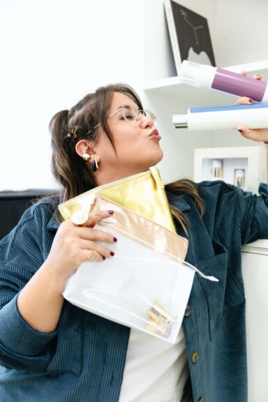 Membro del team Cosmetu che scherza con flaconi di skincare e pochette beauty, a rappresentare creatività e cura del packaging cosmetico
